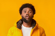 © Prostock-studio - Young emotional surprised bearded man standing with open mouth over orange background, winter set
