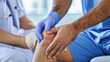 © Manatphon - A healthcare professional examines a patient's knee, wearing gloves and providing care in a clinical setting.