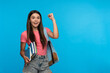 © InsideCreativeHouse - Extremely happy girl high school female pupil student teenager with backpack holding books copybooks winning gesture celebrating having success standing isolated on blue background copy space