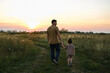 © Elen Nika - Father and little son walking in the field in summer at sunset
