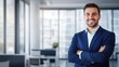 © twinklewin labs - Photo of a young businessman in suit with arms crossed on an office background, space for text