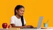 © Pixora Labs - School girl in front of a laptop on a yellow background, space for text