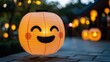 © Pixteegraph - A cheerful pumpkin lantern with a smiling face illuminates a festive outdoor setting, surrounded by glowing decorations.