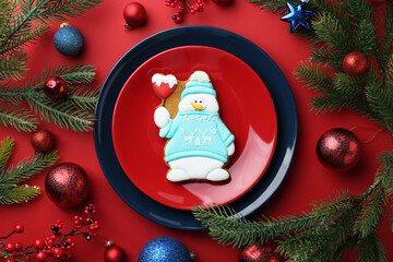 Poster - Delicious cookie in shape of snowman and Christmas decor on red table, flat lay