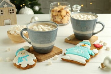 Poster - Delicious cookies in shape of snowmen, cups with cocoa and Christmas decor on white wooden table