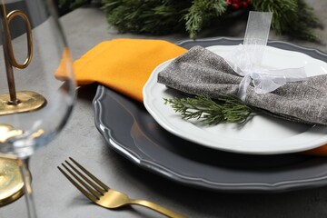 Christmas place setting with festive decor on grey table, closeup