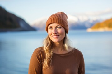 Poster - Portrait of a blissful woman in her 40s sporting a trendy beanie isolated on beautiful lagoon background