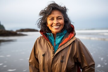 Canvas Print - Portrait of a grinning indian woman in her 60s wearing a windproof softshell isolated in peaceful tide pool background