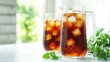 © Pannin - A pitcher of iced sweet tea with two glasses, neatly arranged on a white surface, with the bottom half open for text or promotional content.