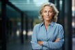 © Markus Schröder - Portrait of a glad woman in her 60s sporting a versatile denim shirt while standing against sophisticated corporate office background