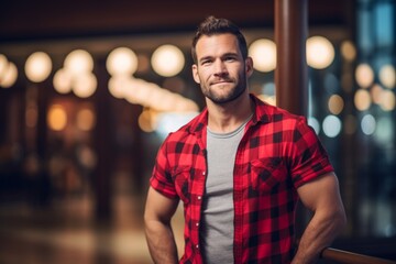 Wall Mural - Portrait of a content man in his 30s wearing a comfy flannel shirt over dynamic fitness gym background