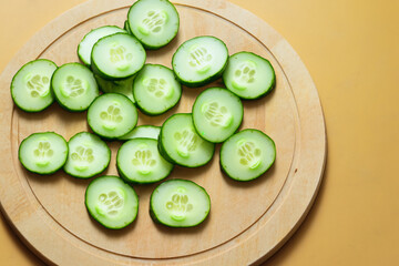 Wooden board with slices of cucumber on it. food healthy green concept. a round of cucumbers and slices of broccoli on a wooden board. a round of cucumbers and other vegetables on a board wooden.