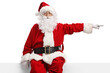 © Ljupco Smokovski - Santa claus sitting on a blank white banner and pointing