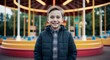 © Arceli - Smiling young Caucasian boy wearing a jacket in an amusement park
