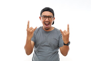 Asian man with beard wearing casual t-shirt and glasses over white background shouting with crazy expression doing rock symbol with hands up. Music star. Heavy music concept.