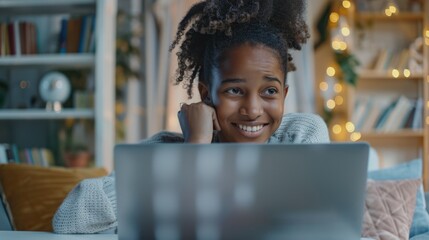 A person sitting on a couch looking at a laptop screen