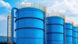 © nitnicha - Large blue industrial storage tanks against a clear blue sky, showcasing robust construction and essential functionality in modern infrastructure.