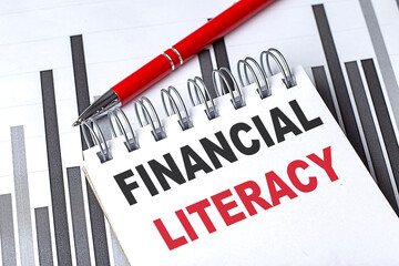 Poster -  Financial literacy text on notebook with red pen and bar charts in the background