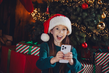 Poster - Photo of charming little girl hold device excited dressed green christmas garment tradition atmosphere decor house indoors room