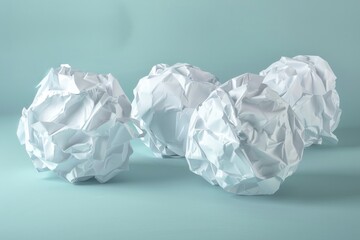 Fototapete - Three crumpled paper balls sit on a blue surface, with a textured and imperfect appearance