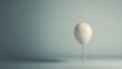 © pjjaruwan - A single, floating balloon in a muted color palette against a blank background, symbolizing hope in emptiness