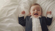 © www.freund-foto.de - Fröhliches Baby im Miniatur-Anzug lacht herzhaft im Bett. Niedliches Konzeptfoto, Karrierebeginn mit Humor. Glückliches Kleinkind, Business-Look. Süße Lebensfreude