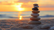 © Sawyer0 - Na tle pięknego zachodu słońca, na plaży, z równowagą ustawiony stos kamieni zen symbolizuje harmonię i wewnętrzny spokój.