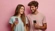 © Oleksandr Kozak - Young happy couple two friends family man woman wear casual clothes hold in hand use mobile cell phone together look to each other isolated on pastel plain light beige color background studio portrait