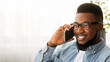 © Prostock-studio - In touch. Handsome african american man in glasses talking on cellphone with somebody, copy space