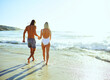 © StarDweller/peopleimages.com - Beach, holding hands and back of couple, water and romance in holiday, walking and bonding in nature. Outdoor, travel and people at sea, fresh air and vacation in summer, waves and together on date