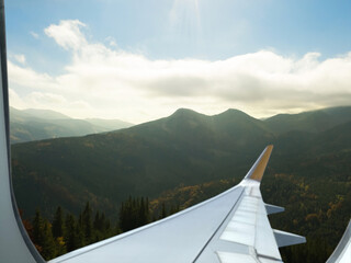 Wall Mural - Airplane taking off or landing, view on mountains from window