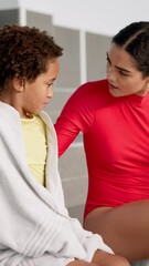 Sticker - Pool, support and swimming coach with child in discussion for progress, development and help in lesson. Boy, towel and woman with conversation at aquatic center for sports, practice and guidance