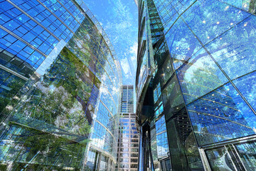 Environment preservation. Double exposure of modern buildings and trees against blue sky, low angle view