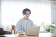 © west_photo - リビングでノートパソコンを使用する日本人大学生の男性