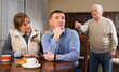 © JackF - Senior man scolding his adult son in presence of mother in living room