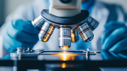 Poster - Close-up of a Microscope with Lens in Focus and a Glowing Stage