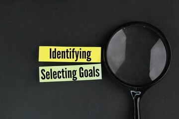 without a magnifying glass and colored paper with the words Identifying and selecting goals. Which is the step 2 of financial planning?