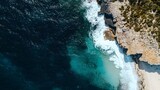 Aerial View of Turquoise Ocean Waves Crashing on Rocky Coastline