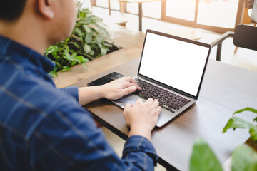 Wall Mural - Close-up image of a man sitting in the cafe and using her laptop. laptop white blank screen mockup for display your graphic banner.