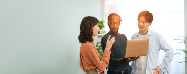 Poster - Multinational people in casual wear having a meeting about business management while looking at a laptop in an office