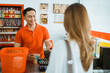 © Odua Images - male shopkeeper serves female shoppers by scanning barcodes at the checkout at the minimarket