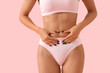 © Pixel-Shot - Young woman in underwear with cellulite problem on pink background, closeup