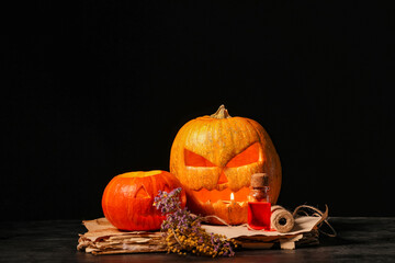 Sticker - Halloween composition with jack-o-lanterns, spell book, flowers and bottle of poison on table near black wall