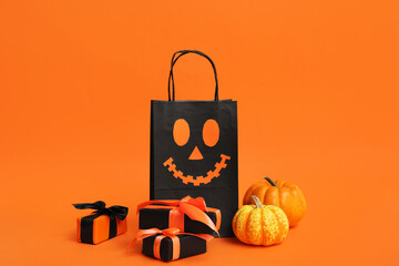 Canvas Print - Shopping bag with Halloween gift boxes and pumpkins on orange background