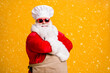 © deagreez - Turned photo of white bearded santa claus in culinary chef headwear cap cross hands cook x-mas christmas jolly meal wear apron sunglass isolated bright shine color background