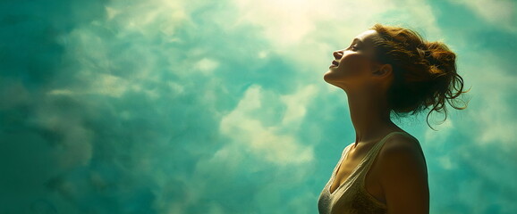 Woman basking in sunlight against ethereal teal sky for spirituality and freedom concepts