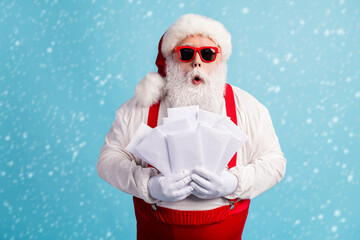 Portrait of his he nice attractive amazed stunned thick white-haired Santa holding in hand pile stack mail gift wish list isolated bright vivid shine vibrant blue color background