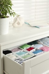 Wall Mural - Chest of drawers with different folded clothes indoors, closeup