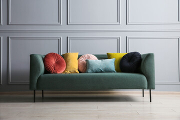 Wall Mural - Stylish sofa with cushions near grey wall