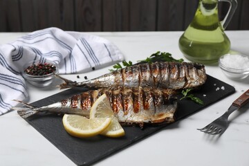 Delicious grilled mackerel, parsley, spices and lemon on white table